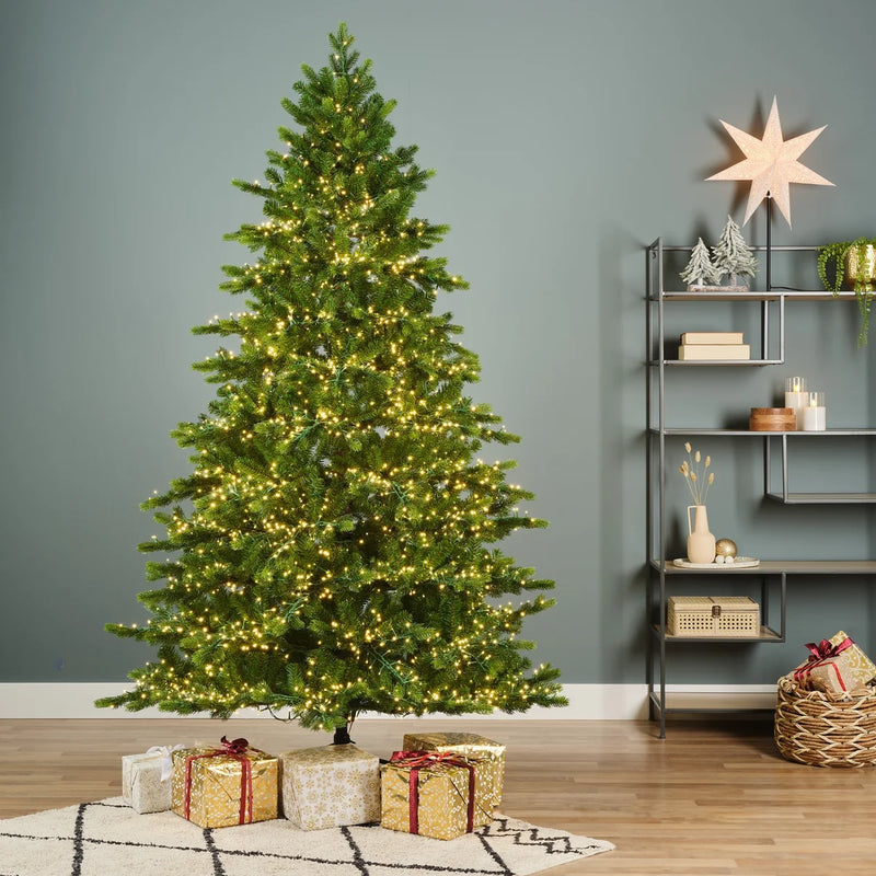 Everlands Galloway Spruce pre-lit Christmas tree beside shelving, with wrapped presents beneath