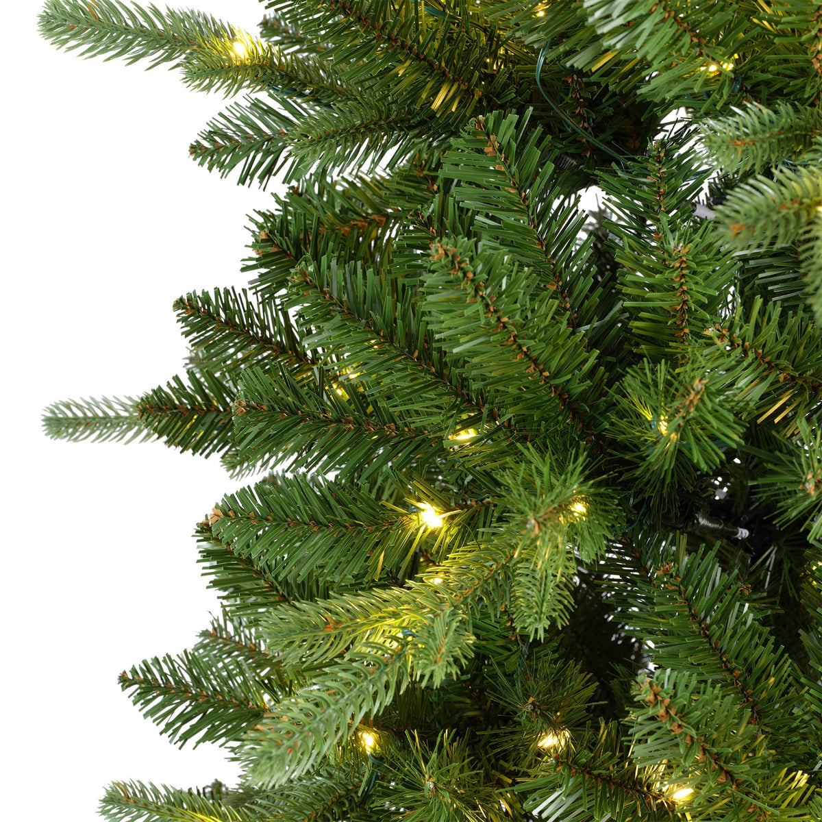 Close-up of green artificial needles and warm white LED lights on the Everlands Killington Christmas tree